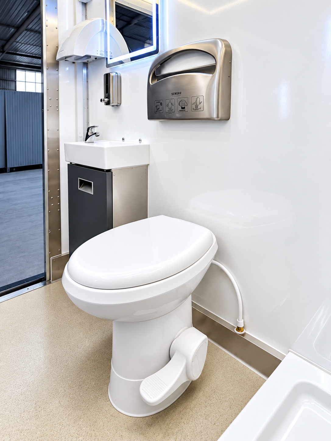 Commercial restroom-only trailer interior with toilet, vanity and mirror